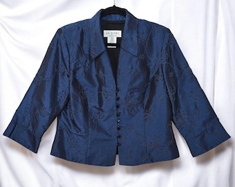 May include: A navy blue jacket with floral embroidery. The jacket has a notched collar, three-quarter sleeves, and a button-down front. The jacket is hanging on a black hanger against a white backdrop.
