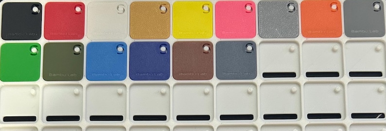 May include: A color chart with 10 different colored squares. The squares are arranged in two rows of five. The colors are black, red, white, brown, yellow, pink, gray, orange, green, and blue.