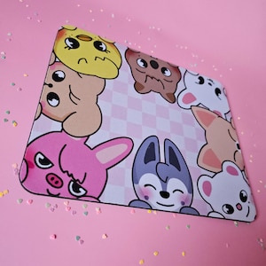 May include: A pink and white mouse mat with a checkered pattern. The mouse mat features cartoon animals, including a pink bunny, a grey wolf, a brown bear, a white dog, and a yellow chick.