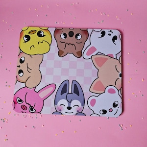 May include: A pink and white checkered mouse mat with cartoon animal faces around the border. The animals include a yellow chick, a brown bear, a white bunny, a pink bunny, a grey wolf, a brown dog, and a white bear.