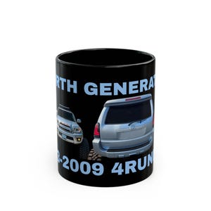 Könnte beinhalten: Ein schwarzer Keramikbecher mit einer Grafik eines silbernen SUVs aus Vorder- und Rückansicht. Der hellblaue Text lautet 4TH GENERATION und 2003-2009 4RUNNER. Das Design ist auf einem einfarbigen schwarzen Hintergrund auf der Außenseite gedruckt.