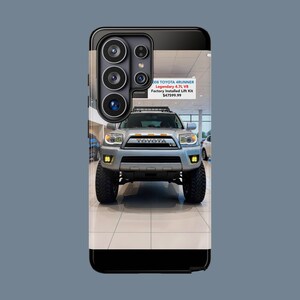 May include: A black smartphone case featuring a printed image of a silver 2008 Toyota 4Runner with a V8 engine and a factory installed lift kit. The text on the case reads 2008 TOYOTA 4RUNNER Legendary 4.7L V8 Factory Installed Lift Kit $47599.99.