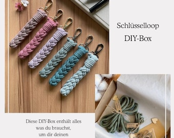 May include: Braided rope keychains in shades of pink, purple, and blue with gold and black hardware. The image also shows a DIY box with green rope and the text "Schlüsselloop DIY-Box". The text on the image says "This DIY box contains everything you need to make your own key loop in your desired colors!"