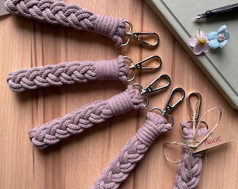 May include: Five braided keychains in a dusty rose color with gold key rings. The keychains are made of a soft, woven material and are a great way to add a touch of personality to your keys.