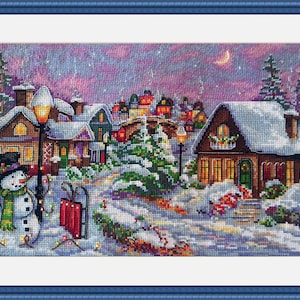 May include: A cross-stitch winter scene shows a snow-covered village at dusk. A snowman with a top hat and scarf stands near a red sledge. Houses with lit windows and snow-covered roofs are visible.