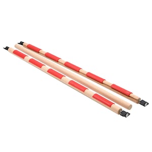 Pode incluir: Duas hastes cilíndricas de madeira com pegas de silicone vermelho espaçadas uniformemente ao longo do comprimento. Cada haste está equipada com pequenas tampas de plástico preto e botões de tensão pretos ajustáveis nas pontas.