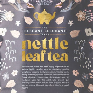 Könnte beinhalten: Eine schwarze und goldene Packung Brennnessel-Blatt-Tee von The Elegant Elephant Tea Co. Die Packung zeigt ein florales Design und eine Illustration einer goldenen Elefanten-Teekanne. Der Text auf der Packung lautet "nettle leaf tea" und "125g / 4.4oz".