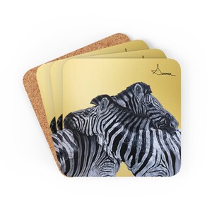 May include: Set of four coasters featuring a black and white illustration of two zebras nuzzling each other on a gold background. The artist's signature, "Summa", is in the top right corner.
