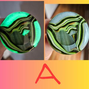 May include: Two circular glass objects with a swirling pattern of green, black, and white. One glows bright green. The other has a light blue background. The letter "A" is written in red below the objects.