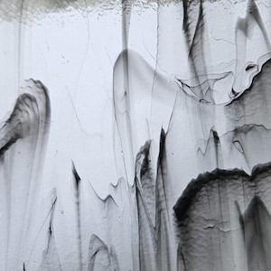 May include: Abstract close-up of a textured glass panel. The panel features flowing, organic patterns in shades of gray and black against a white background. The design resembles smoke or water currents, creating a dynamic visual effect.