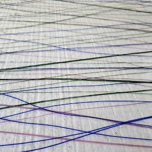 May include: Abstract artwork featuring a white background with intersecting lines in shades of blue, green, and pink. The lines vary in thickness and create a dynamic, textured effect. The artwork has a modern, minimalist aesthetic.