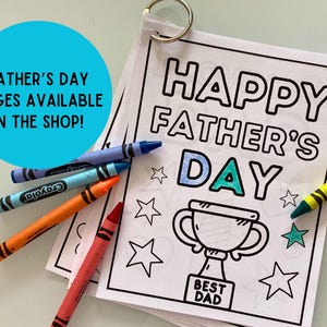 May include: A black and white coloring page with the text "Happy Father's Day" and a trophy with the text "Best Dad". The page is surrounded by crayons.