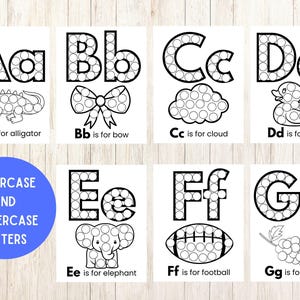 Op de afbeelding: Een set van zeven educatieve alfabetwerkbladen met hoofdletters en kleine letters van A tot G. Elke letter is ontworpen met een stippatroon, vergezeld van een bijbehorende illustratie van een alligator, strik, wolk, eend, olifant, voetbal of druif, met tekstlabels.