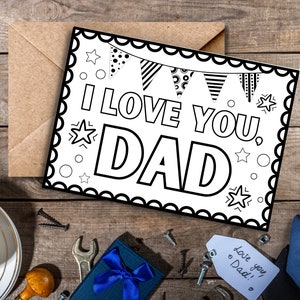 May include: A black and white printable card with a scalloped border. The card says "I love you, Dad" with a banner of flags and stars around the text.