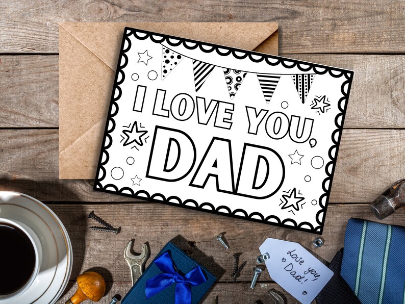 May include: A black and white printable card with a scalloped border. The card says "I love you, Dad" with a banner of flags and stars around the text.