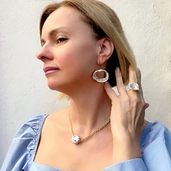 Parure de bijoux blancs éclectiques : grosses boucles d'oreilles en dentelle, bague délicate fleur blanche et tour de cou tendance en or