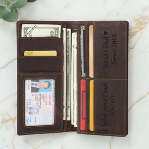 May include: Open brown leather wallet filled with banknotes, credit cards, and an ID card. The wallet has multiple compartments and features the text "I love you Dad - Sarah" and "Sarah's Dad Since 2018".