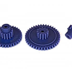 Può includere: Tre ingranaggi in plastica blu di diverse dimensioni. L'ingranaggio più grande ha 36 denti e un ingranaggio più piccolo con 12 denti è montato al centro. L'ingranaggio più piccolo ha 12 denti.