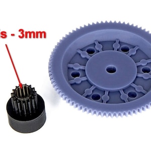 May include: Two gears, one large and one small, are shown against a white backdrop. The larger gear is a light blue colour and has a circular design with multiple holes. The smaller gear is black. Text indicates the hole is 3mm.