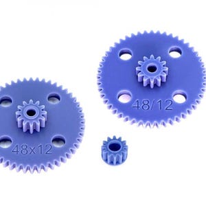 Può includere: Due ingranaggi composti in plastica viola identici e un piccolo pignone viola. Ogni ingranaggio composto presenta una grande ruota esterna con 48 denti e una ruota centrale più piccola con 12 denti, con il testo 48/12 impresso sulla superficie.