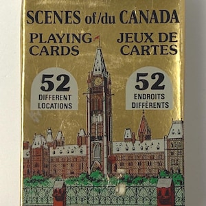 May include: A gold-colored box of "SCENES of/du CANADA PLAYING CARDS." The box features an illustration of a building with a clock tower and the text "52 DIFFERENT LOCATIONS" and "52 ENDROITS DIFFÉRENTS."