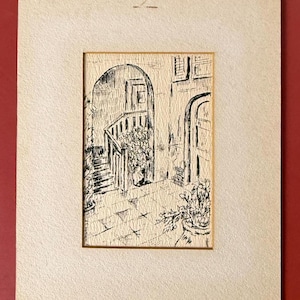 May include: A black and white ink drawing of an outdoor scene with an arched doorway, stairs, and potted plants. The artwork is framed in a cream-colored mat.