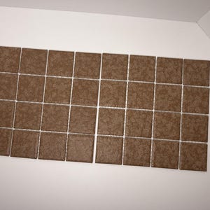 May include: A rectangular grid of thirty-two square brown tiles arranged in four rows of eight. Each tile features a subtle, mottled, and textured surface pattern in varying shades of brown, creating a uniform and consistent appearance across the set.