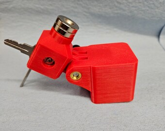 May include: A red 3D printed key holder with a magnetic top and a hinged side. The key holder is designed to hold a single key.