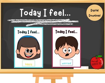 May include: A black chalkboard with the text "Today I feel..." written in white chalk. There are two cards on the chalkboard, each with a cartoon face and the text "Today I feel..." The first card shows a happy face with the word "happy" below it. The second card shows a worried face with the word "worried" below it.