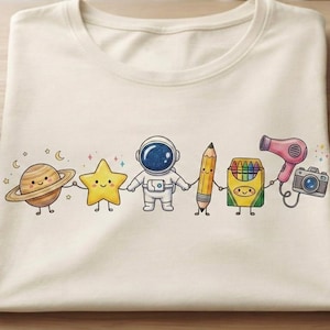 Peut inclure: Un t-shirt couleur crème avec une impression graphique représentant une ligne de personnages de dessin animé se tenant par la main, incluant une planète, une étoile jaune, un astronaute, un crayon, une boîte de crayons, un sèche-cheveux rose et un petit appareil photo.