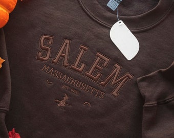 Op de afbeelding: Bruin sweatshirt met "SALEM MASSACHUSETTS EST. 1626" geborduurd op de voorkant.