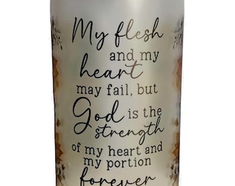 May include: A frosted glass jar with a bamboo lid features a quote from Psalm 73:26, "My flesh and my heart may fail, but God is the strength of my heart and my portion forever." The jar has a floral design with brown and gold accents.