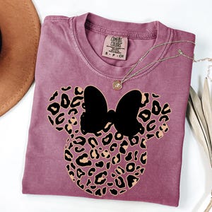 May include: A set of three ceramic mugs with a speckled, matte finish. The mugs are in shades of cream, light gray, and dark gray. Each mug has a simple, minimalist design and a rounded handle.