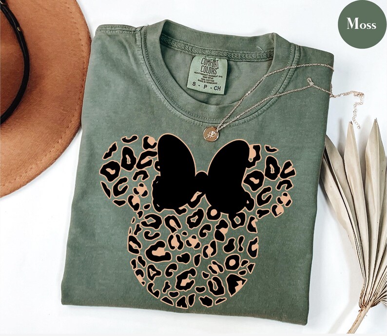 May include: A set of three ceramic mugs with a speckled, matte finish. The mugs are in shades of cream, light brown, and dark brown. Each mug has a simple, minimalist design and a rounded handle.