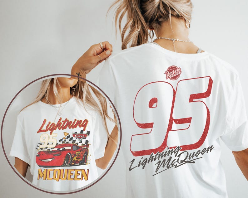 Op de afbeelding: Wit T-shirt met een Lightning McQueen-afbeelding. De voorkant toont "Lightning McQueen 95" met een rode raceauto en geblokte vlag. De achterkant heeft een grote rode "95" en "Lightning McQueen" tekst. Een vintage ontwerp.