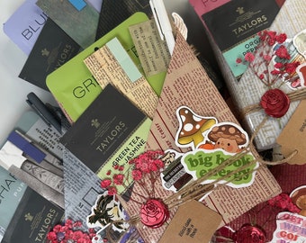 May include: A collection of wrapped books with various decorative elements, including red roses, a mushroom sticker, and a sticker that says "big book energy". The books are wrapped in brown paper with a twine bow and a red wax seal.