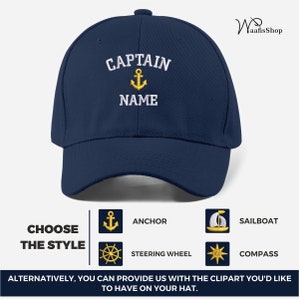 May include: A navy blue baseball cap with white embroidered text that reads "CAPTAIN" with an anchor symbol and the word "NAME" underneath.  The cap has a gold anchor, steering wheel, sailboat, and compass design options.