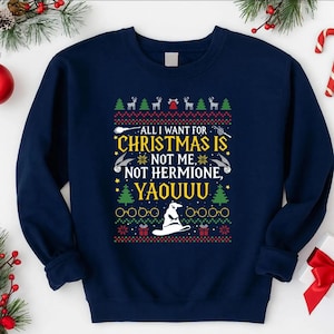 Könnte beinhalten: Marineblaues Sweatshirt mit weihnachtlichem Design. Der Text lautet: "ALL I WANT FOR CHRISTMAS IS NOT ME, NOT HERMIONE, YAOUUU." Das Design umfasst Weihnachtsbäume, Rentiere und einen Zaubererhut.