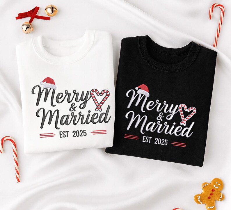 Op de afbeelding: Twee sweatshirts, &eacute;&eacute;n wit en &eacute;&eacute;n zwart, met de tekst "Merry & Married EST 2025". Het ontwerp bevat een kerstmuts en een zuurstokhart. Feestelijke kleding voor een stel.