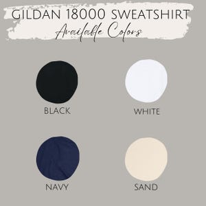 May include: Image showcasing a Gildan 18000 sweatshirt, with a display of available colors. The colors include black, white, navy, and sand, each presented as a solid circle against a gray background. The text "Available Colors" is written in cursive.