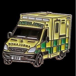 May include: A yellow and green ambulance pin with the word "AMBULANCE" printed on the side and the number "999" on the front bumper.