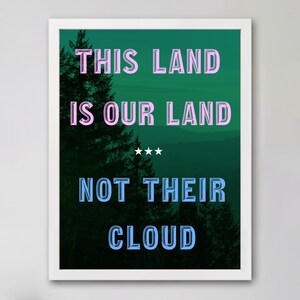 Op de afbeelding: Een ingelijste kunstdruk met een donkergroene boslandschap achtergrond. De tekst luidt THIS LAND IS OUR LAND in roze, gevolgd door drie witte sterren en NOT THEIR CLOUD in blauw. De letters hebben een driedimensionaal afgeschuind effect.