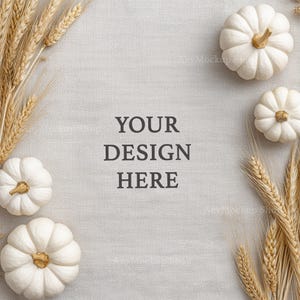 May include: A square image featuring white pumpkins with gold stems and wheat stalks arranged on a light grey textured surface. The text "YOUR DESIGN HERE" is centered in the image. The pumpkins are a fall harvest theme.