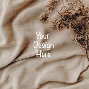 May include: A beige linen fabric background with dried flowers in the upper right corner. The text "Your Design Here" is written in white in the center of the image.