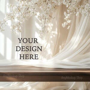 May include: A wooden table top with a white sheer curtain and white cherry blossoms hanging above. The text "YOUR DESIGN HERE" is written on the white wall behind the table.