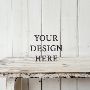 Può includere: Piano di tavolo in legno sbiancato con finitura usurata, su sfondo di pannello di legno bianco. Il testo "YOUR DESIGN HERE" è stampato sullo sfondo.