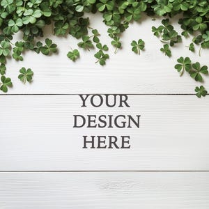 May include: White wooden background with a border of green shamrock leaves. The text "YOUR DESIGN HERE" is centred on the background.