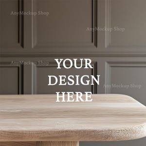 Könnte beinhalten: Eine helle Holztischplatte mit dem Text "YOUR DESIGN HERE" in Weiß. Die Tischplatte befindet sich vor einer grauen Wand mit einem Paneeldesign.