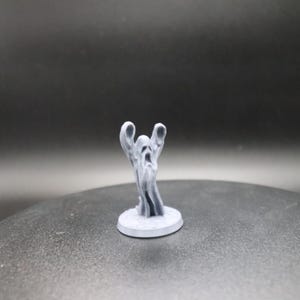 Puede incluir: Una miniatura de un fantasma impresa en 3D de color gris, con los brazos extendidos y una cara gritando. El fantasma está de pie sobre una base redonda.
