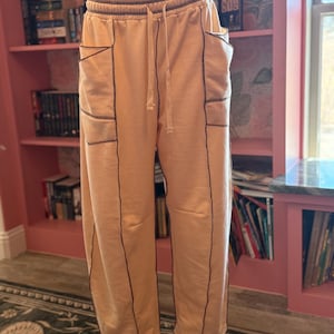 May include: A set of three ceramic mugs with a speckled, matte finish. The mugs are in shades of cream, light gray, and dark gray. Each mug has a simple, minimalist design and a rounded handle.